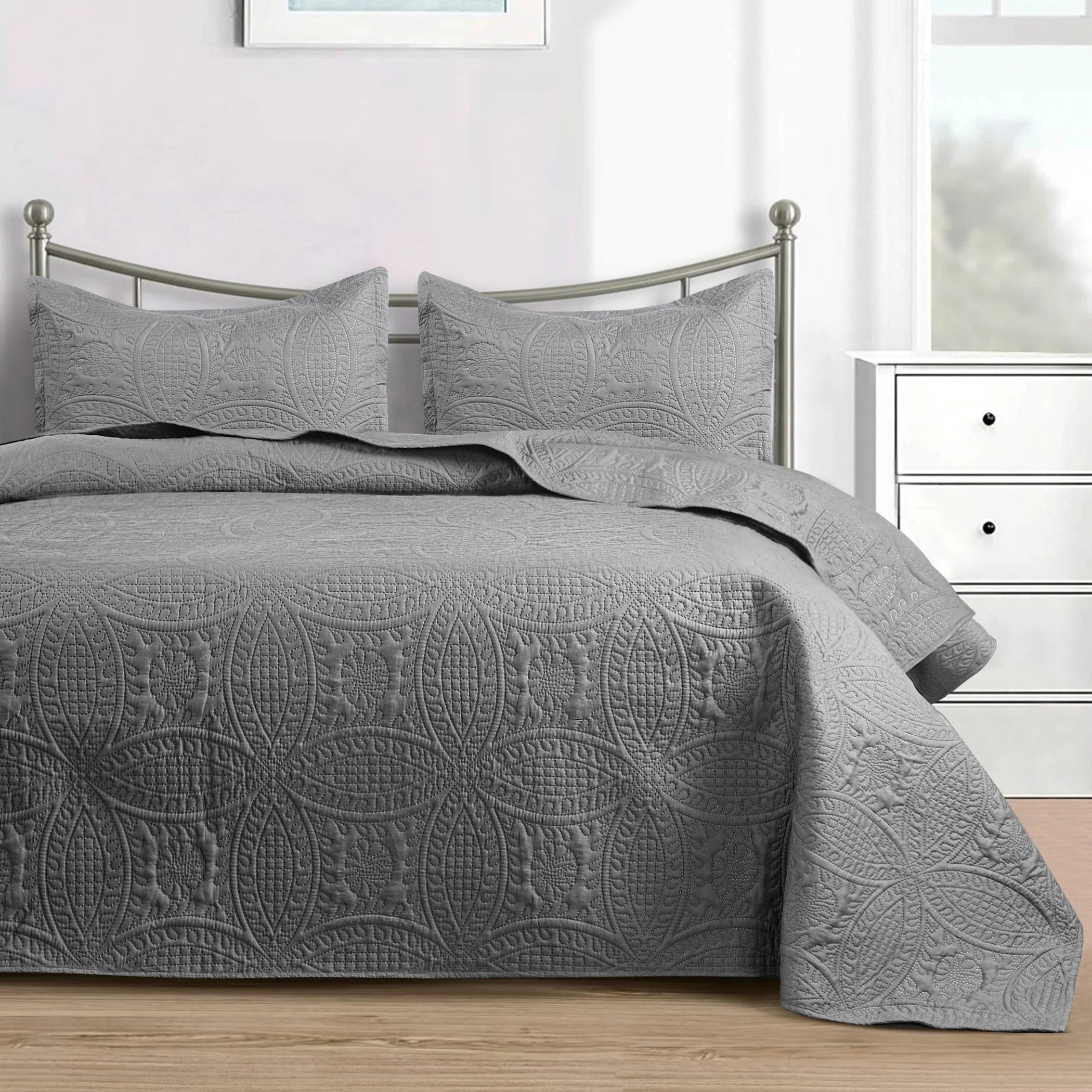 Grey quilted bedspread set with matching pillowcases and embossed coin pattern